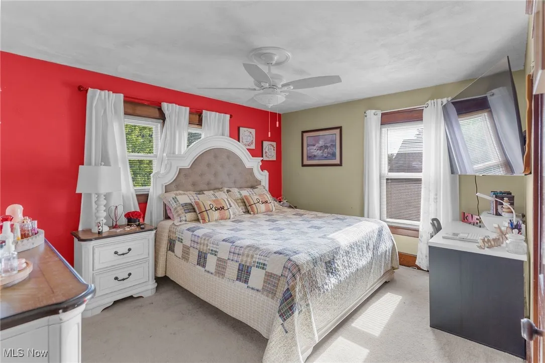 Bedroom with light carpet and a ceiling fan