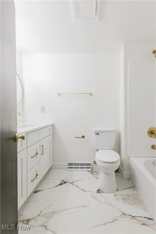 Bathroom with vanity, marble finish flooring, and bathing tub / shower combination