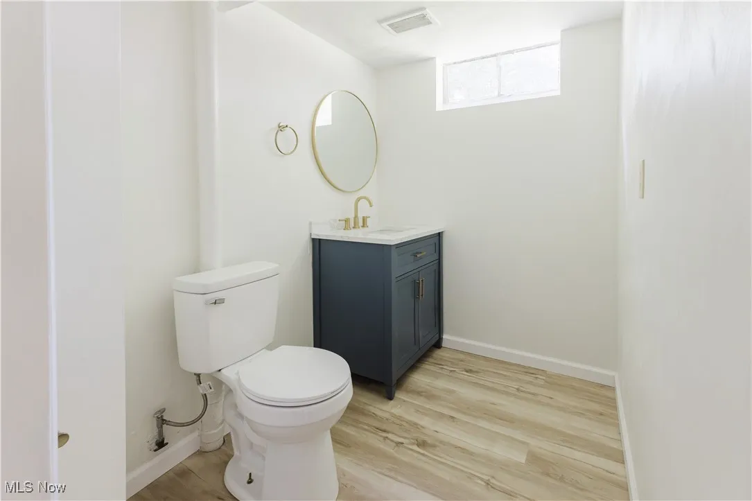 Half bathroom with vanity and wood finished floors