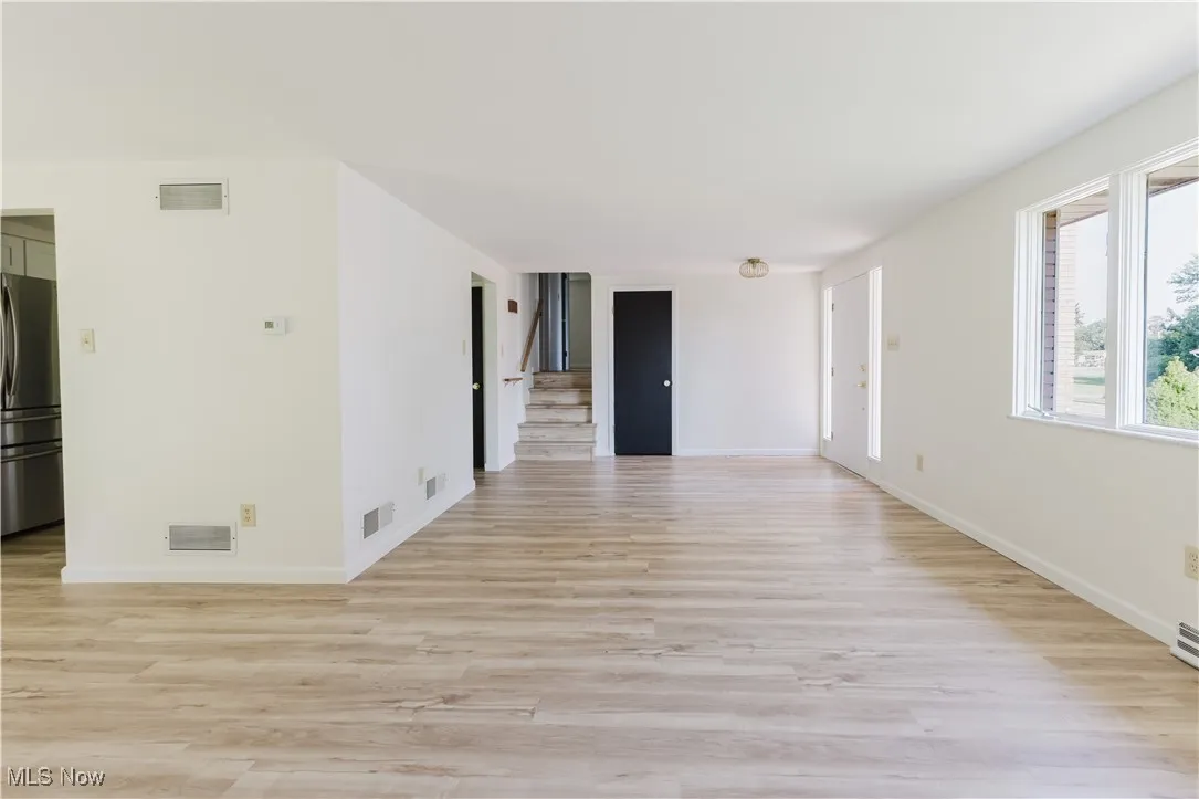 Spare room with light wood-style floors and stairs