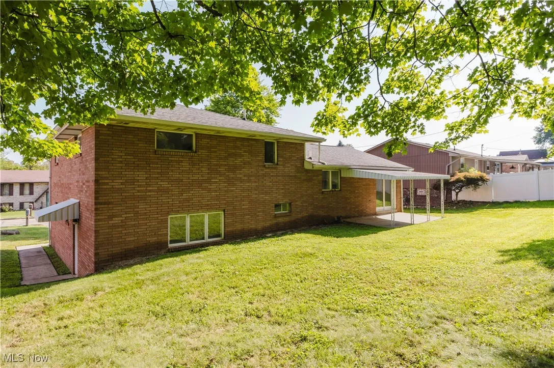 Rear view of house featuring a patio and brick siding