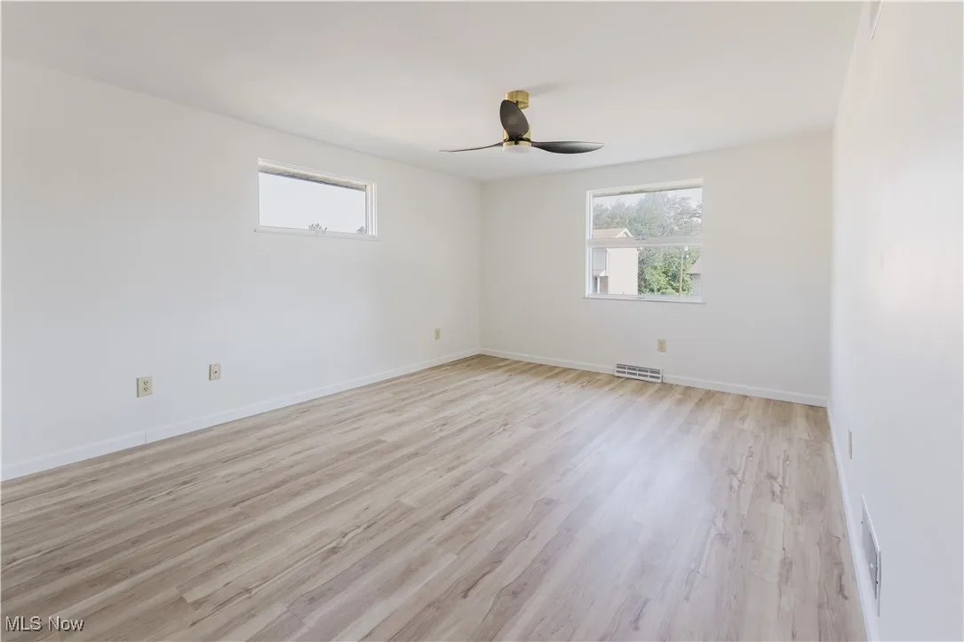 Empty room with light wood-type flooring and a ceiling fan