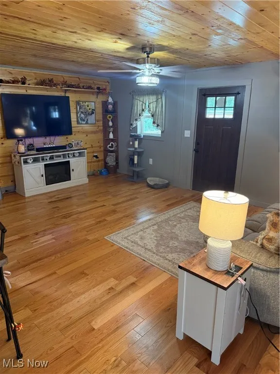 Living room with wood ceiling, light wood finished floors, and a ceiling fan