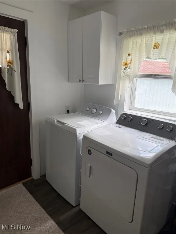 Washroom with separate washer and dryer, cabinet space, and dark wood-type flooring