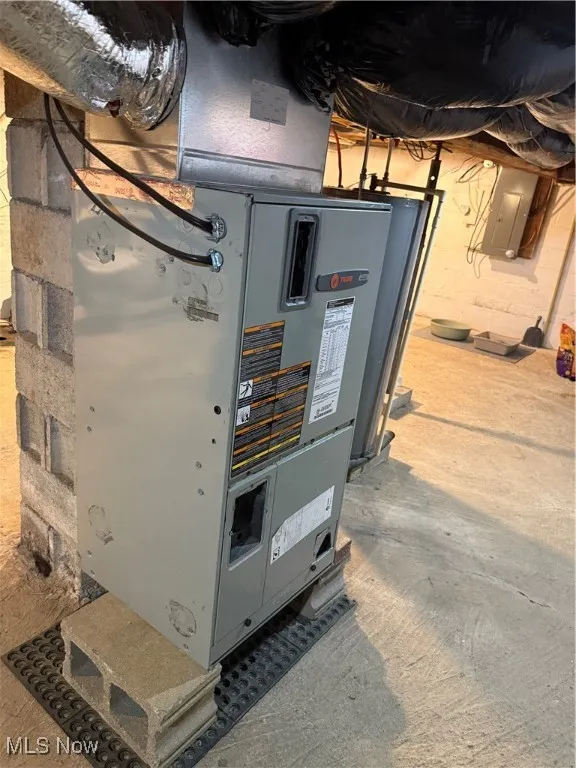 Utilities featuring electric panel, water heater, and heating unit