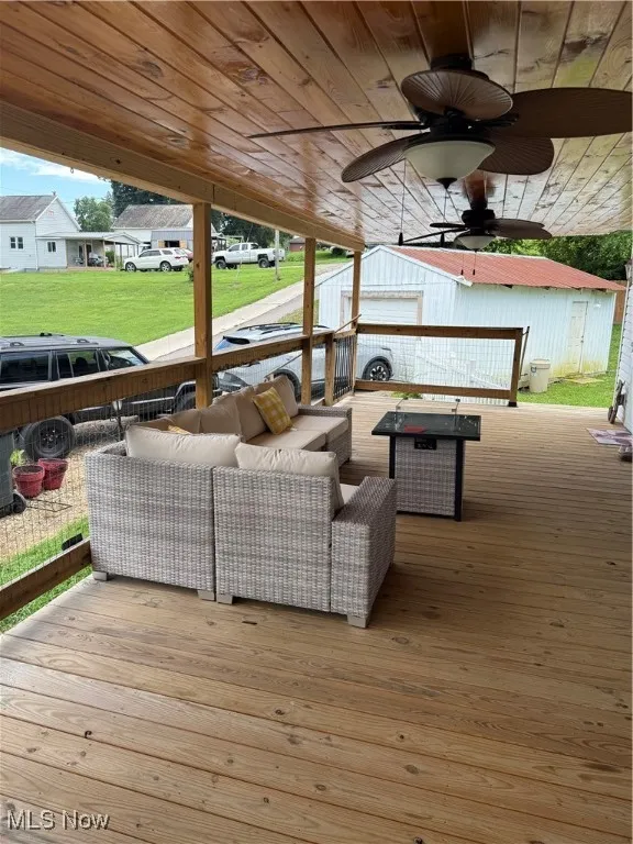 Wooden terrace featuring an outdoor hangout area and a ceiling fan