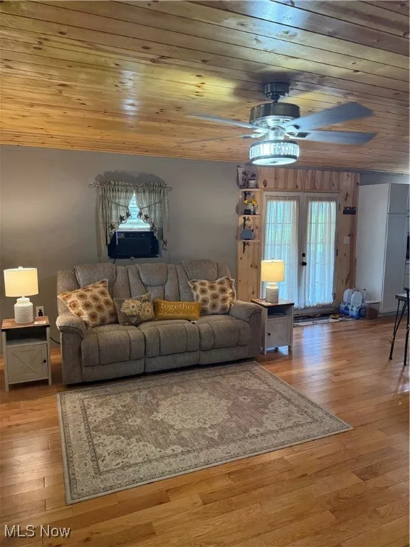 Living room with wooden ceiling, a ceiling fan, and wood-type flooring