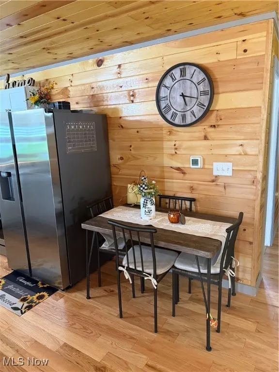 Dining space featuring wooden walls, wood ceiling, wood finished floors, and breakfast area