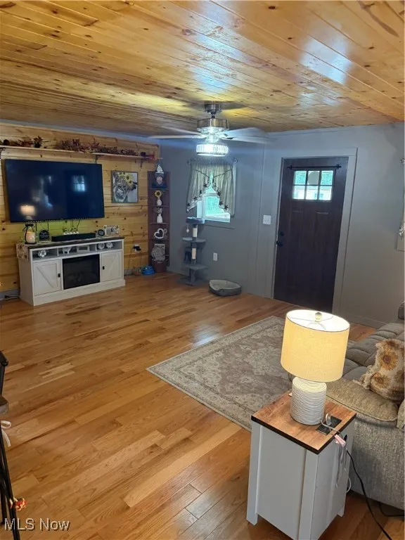 Living area with wood ceiling, a ceiling fan, and light wood-style floors