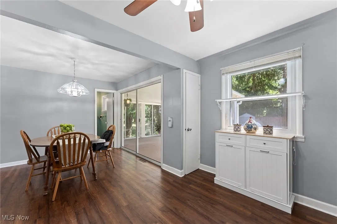 Dining area featuring dark wood like floors, a ceiling fan, and a chandelier