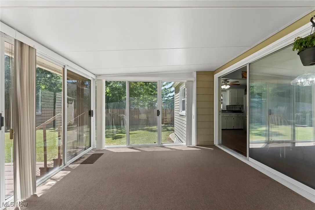 Unfurnished sunroom featuring a ceiling fan and lofted ceiling