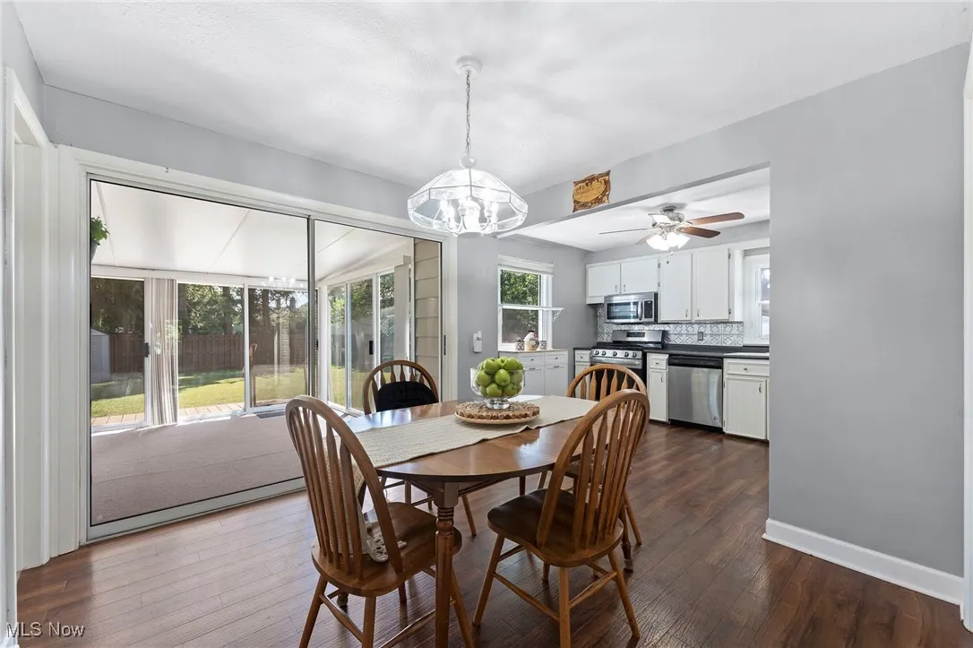 Dining space featuring a chandelier, dark wood like floors, and a ceiling fan