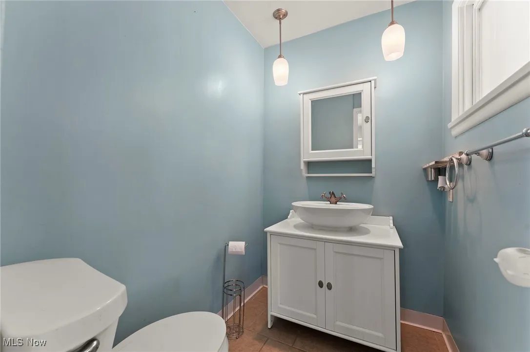 Half bathroom featuring vanity and tile patterned floors