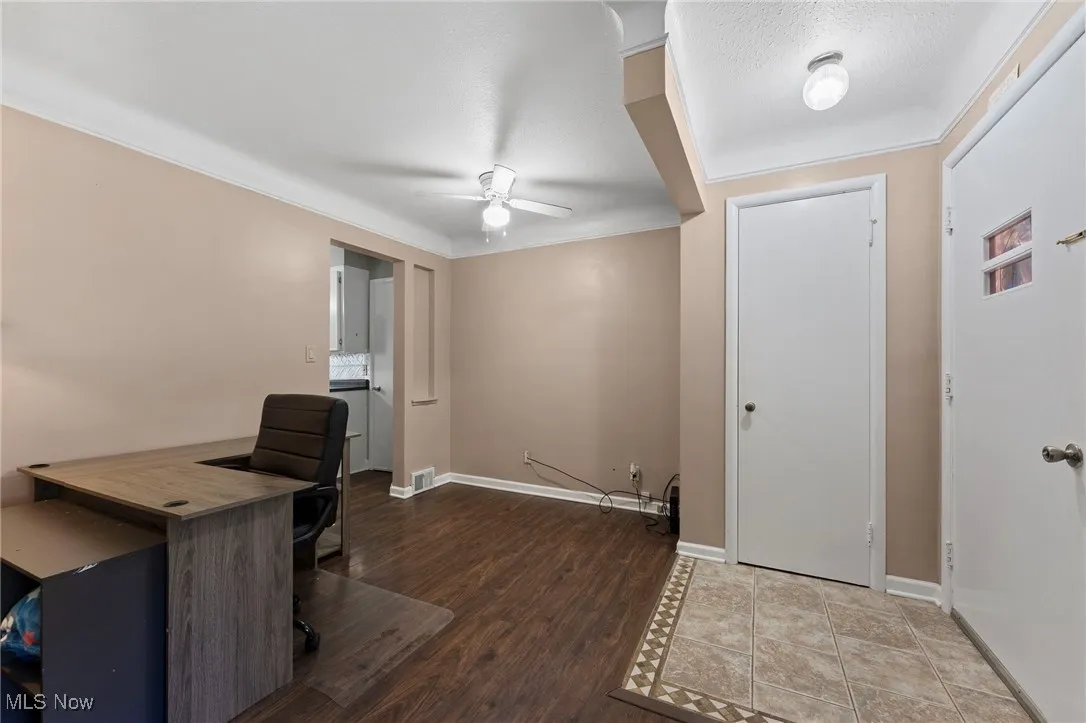 Living roomfeaturing ceiling fan, wood like floors, ornamental molding, and a textured ceiling