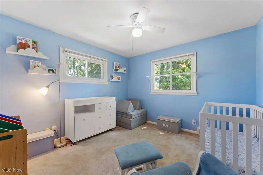 Bedroom featuring multiple windows, carpet flooring, and a ceiling fan