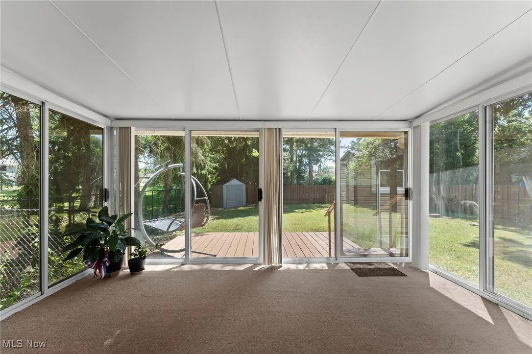 Unfurnished sunroom featuring a deck and carpet