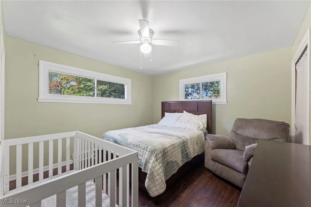 Bedroom with dark wood-style flooring and a ceiling fan
