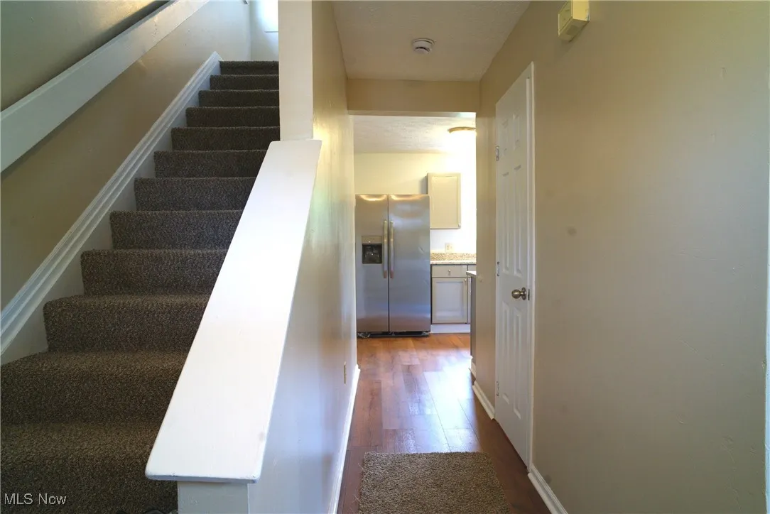 Stairway with wood finished floors and baseboards