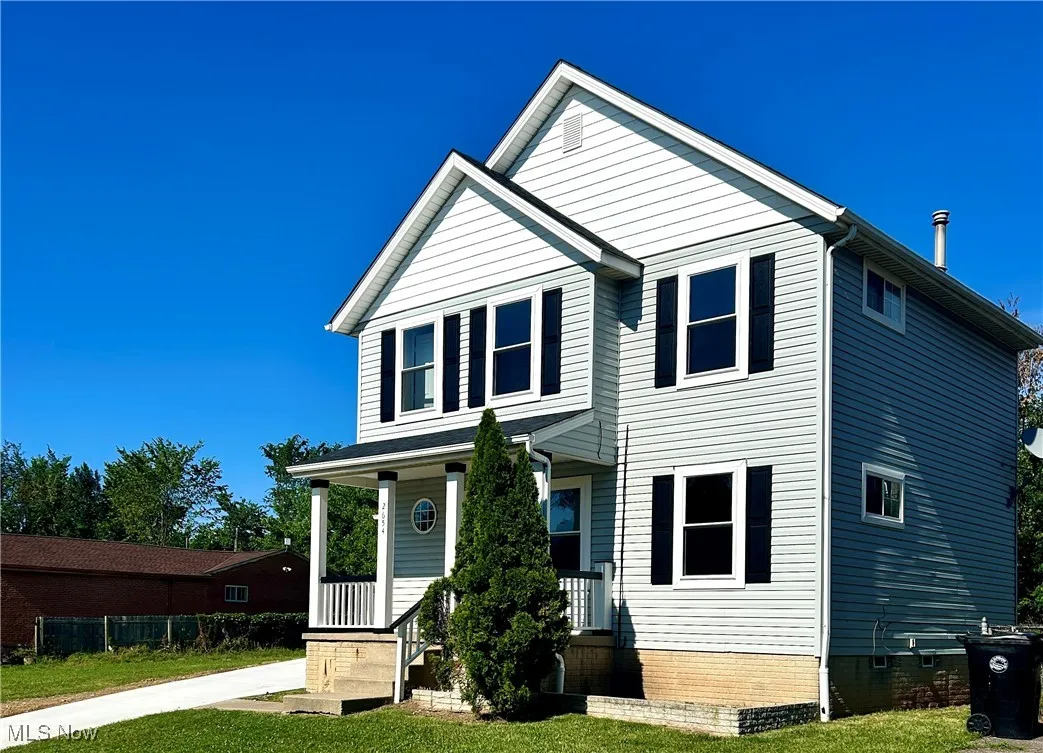 View of front facade with a porch and a front lawn