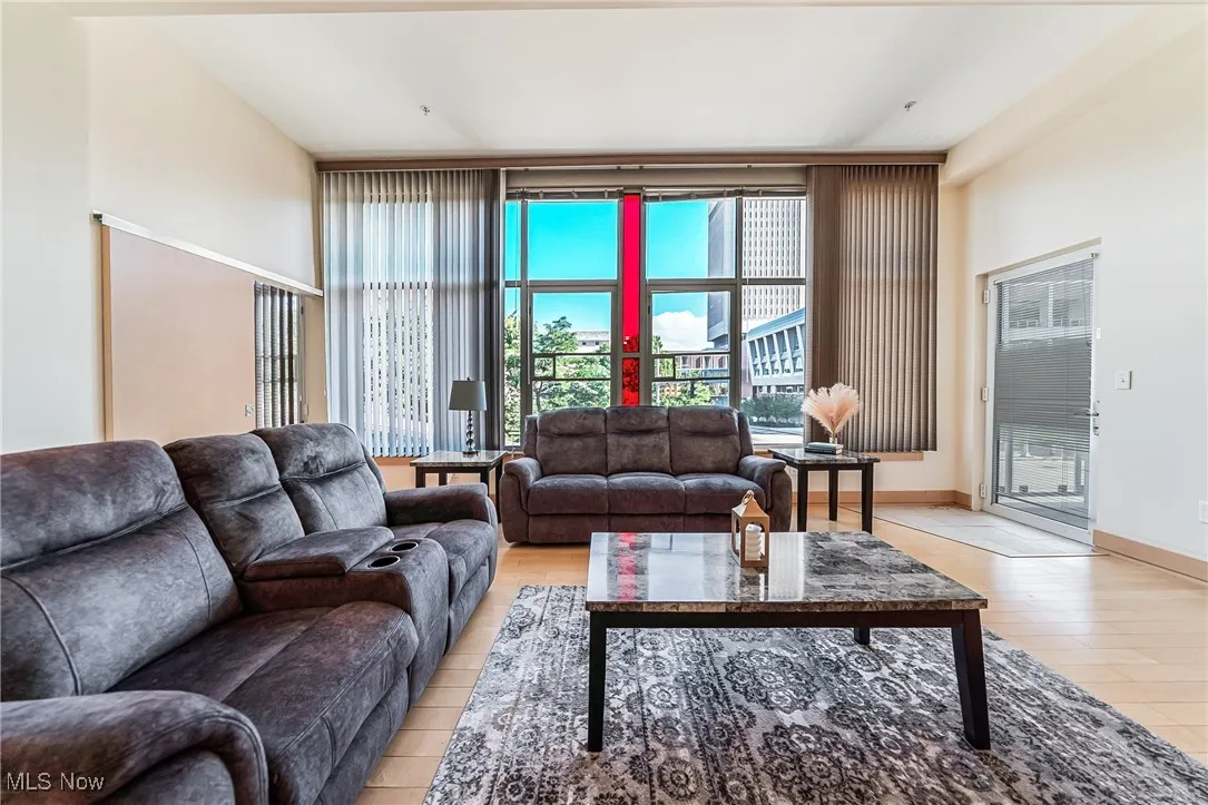 Great room with light wood finished floors and balcony access.