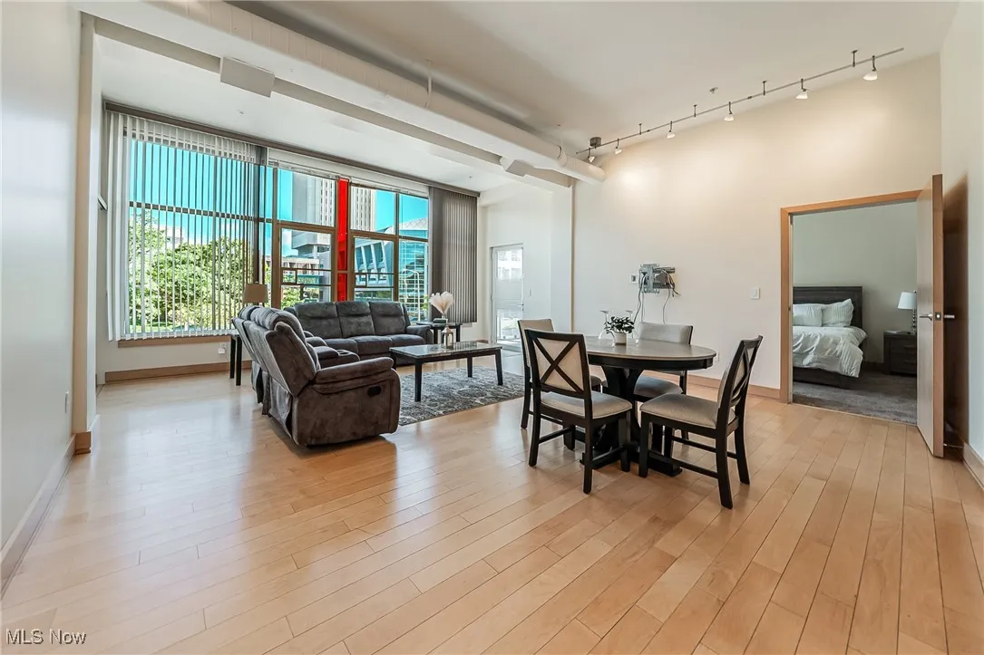 Dining space with light wood-style floors and rail lighting.