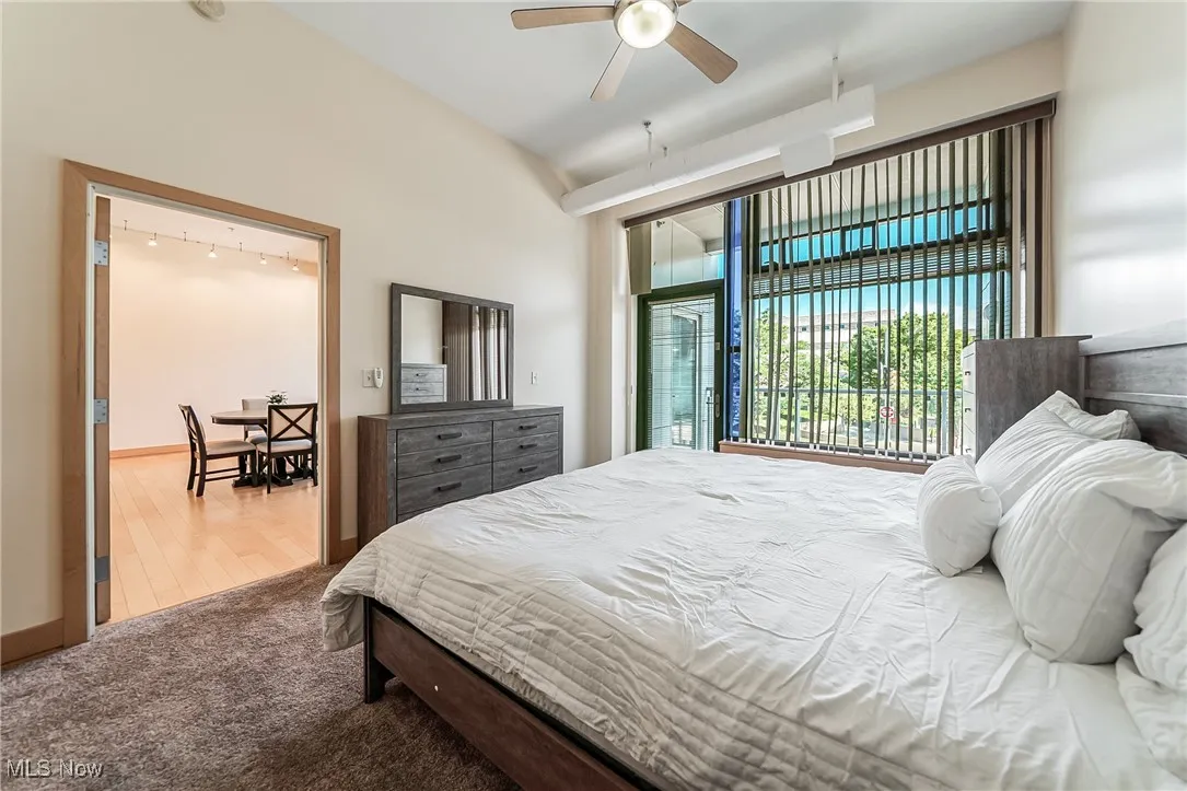Bedroom with carpet, ceiling fan, and balcony access.