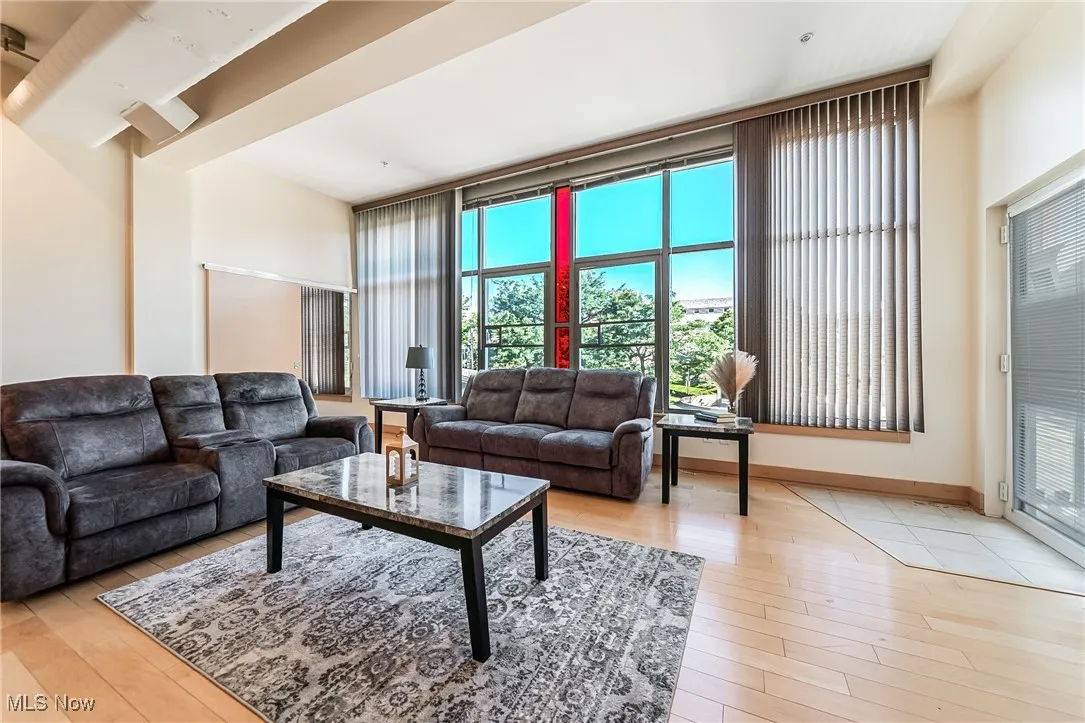 Great room with light wood finished floors and balcony access.