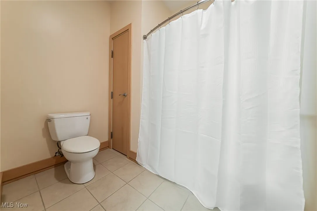 Bathroom featuring tile flooring, storage, and tub/shower combo.