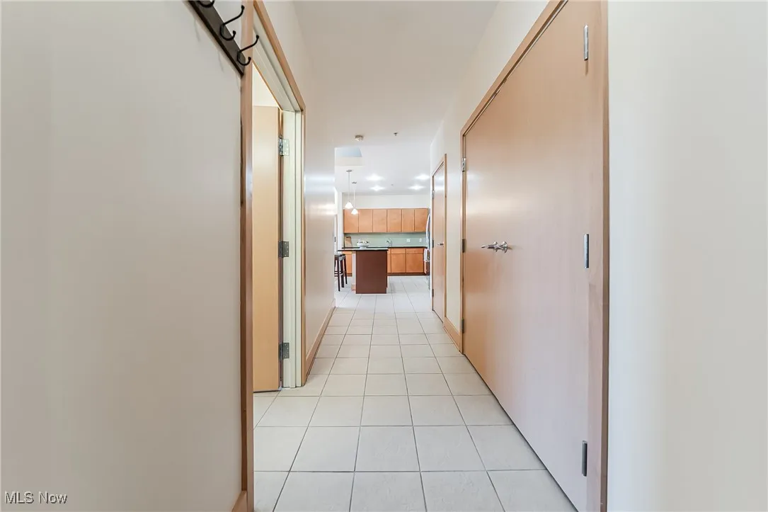Corridor featuring light tile floors and a large closet.