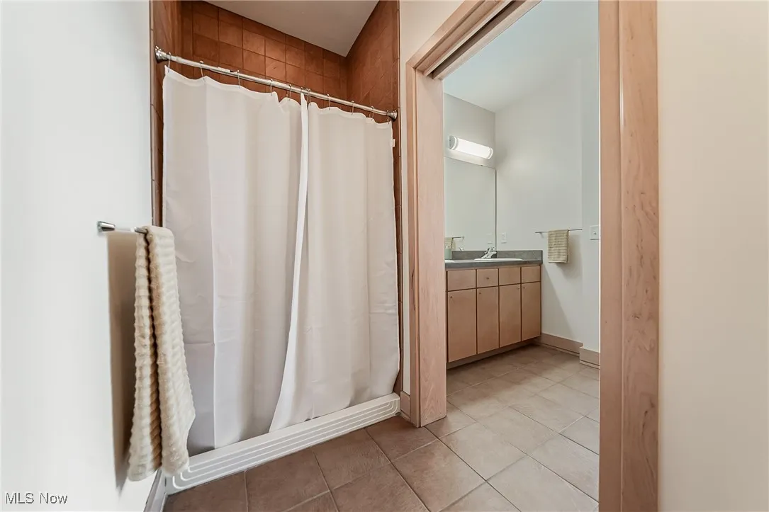 Full bathroom featuring tile floors, vanity, and a walk-in shower.