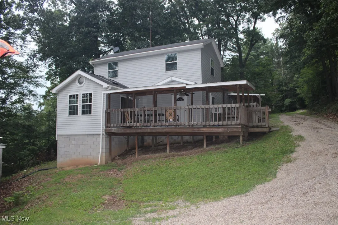 Rear view of house featuring a deck and driveway
