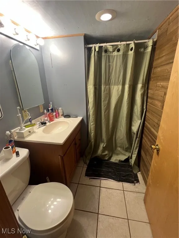 Bathroom featuring tile patterned floors, vanity, and a shower with shower curtain