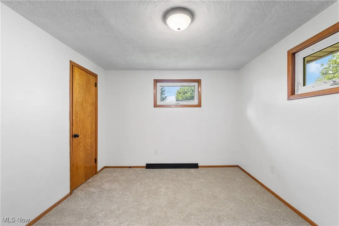 Carpeted spare room with a textured ceiling