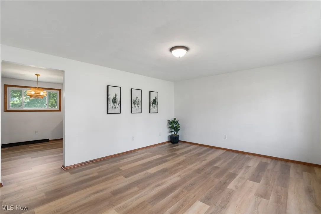 Empty room with light wood-type flooring and baseboards
