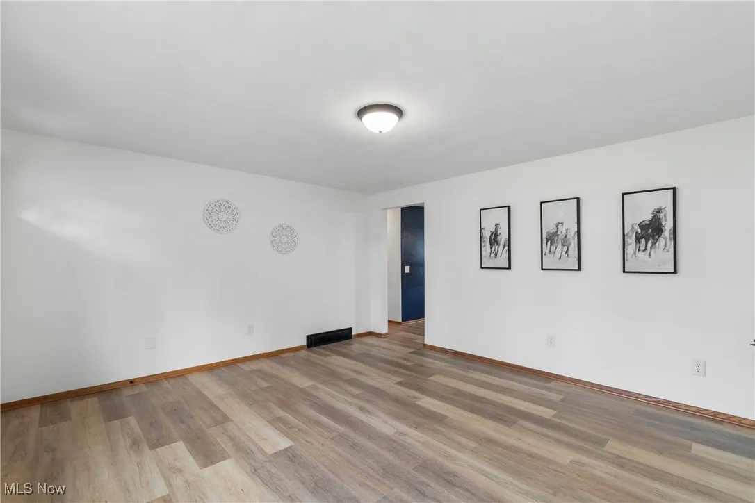 Empty room with light wood-style flooring and baseboards