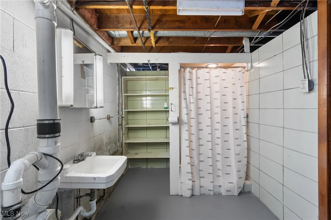 Bathroom with concrete flooring and curtained shower