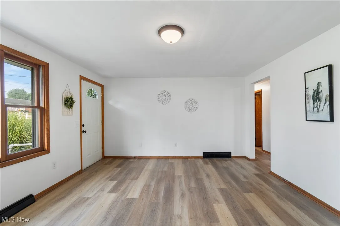 Unfurnished room featuring light wood-style flooring and baseboards