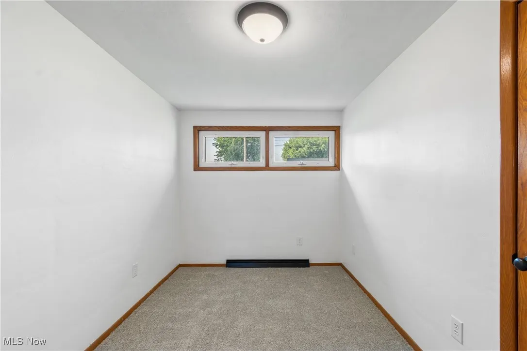 Carpeted empty room with baseboards
