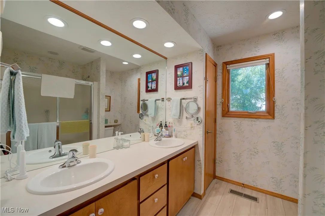 Master bath with double sinks, walk-in shower, and linen closet.