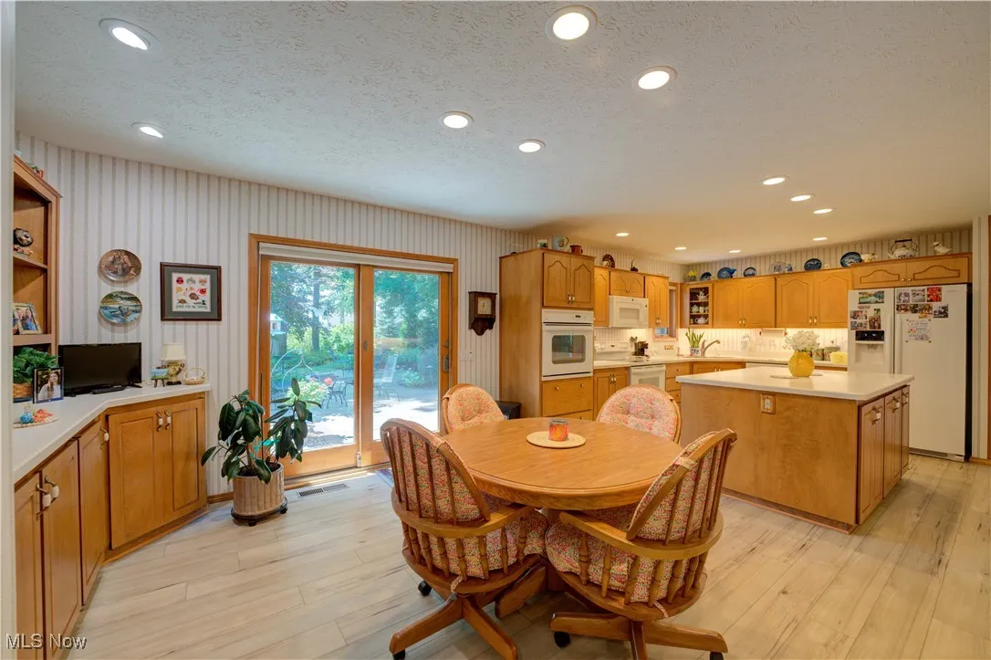 Large eat-in kitchen with center island, built in planning desk, custom breakfront, walk-in pantry, wall oven, plus all appliances will remain. Sliding door out to the scenic rear yard and patio.