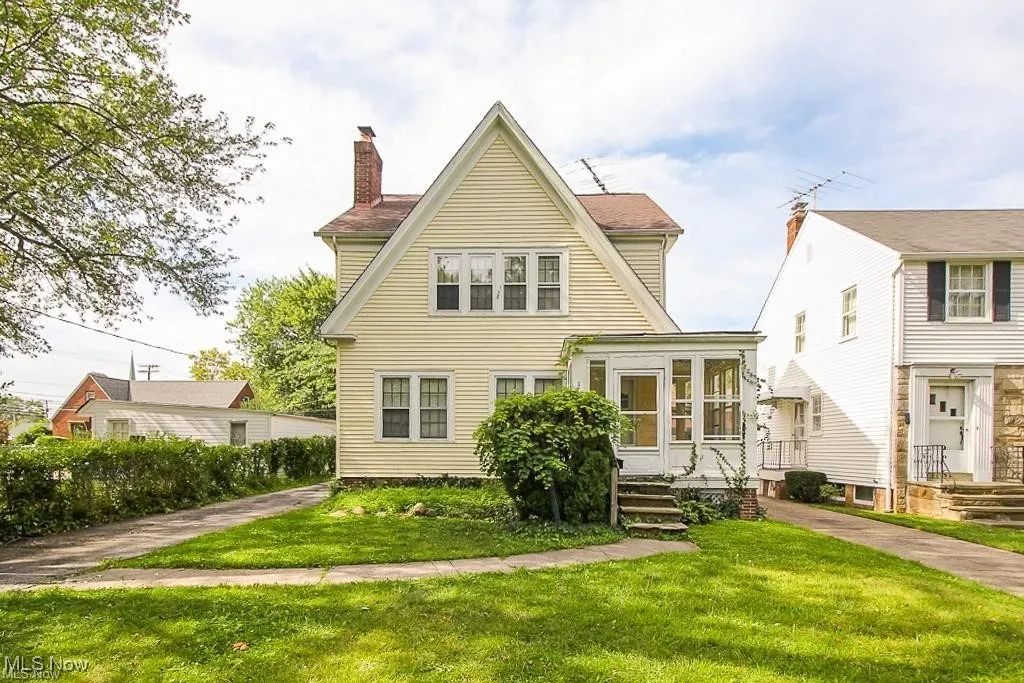 Rear view of house featuring a chimney and a lawn
