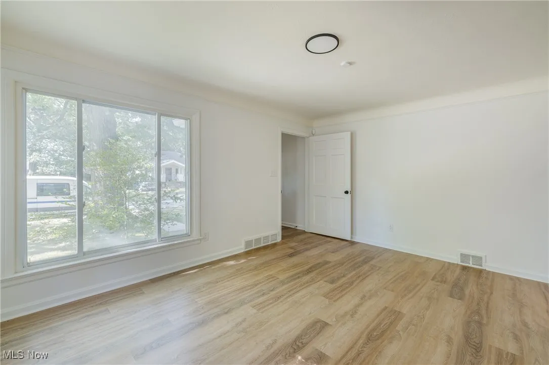 Spare room with light wood-style floors and baseboards