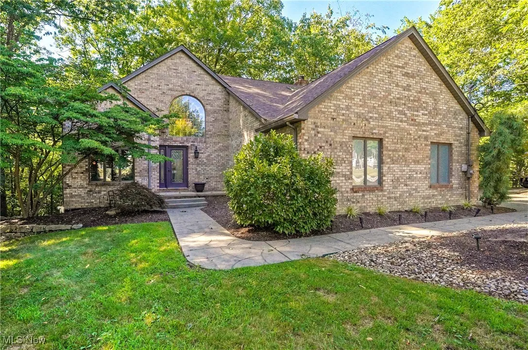 View of front of home with brick siding and a front lawn