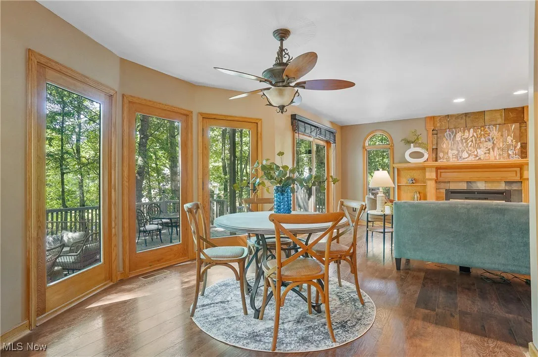 Dining space featuring wood-type flooring, ceiling fan, a fireplace, and recessed lighting
