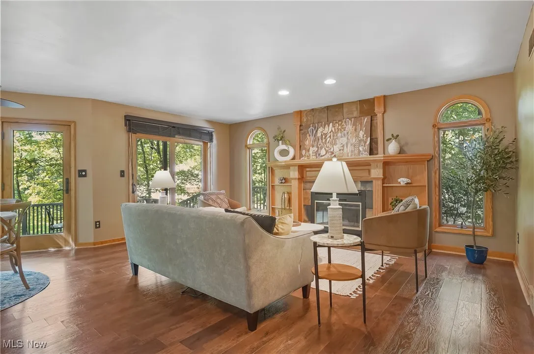 Living area with wood-type flooring, recessed lighting, and a glass covered fireplace