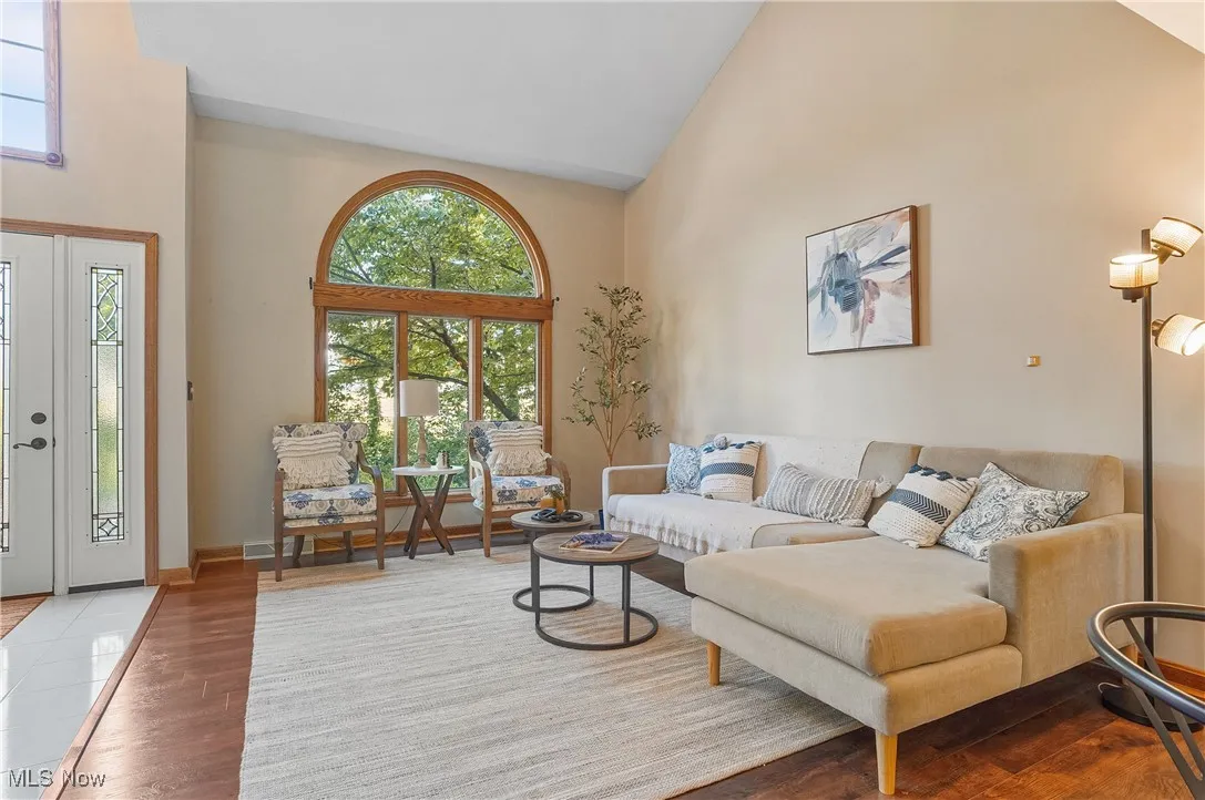 Living room featuring high vaulted ceiling and wood finished floors