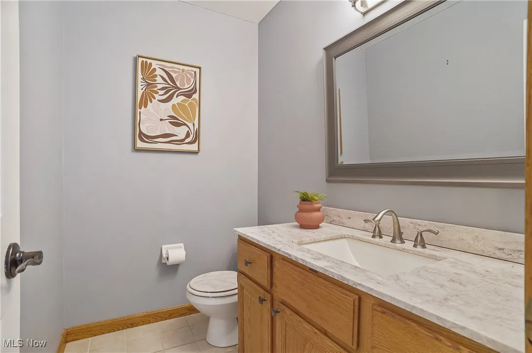 Half bathroom with vanity and tile patterned floors
