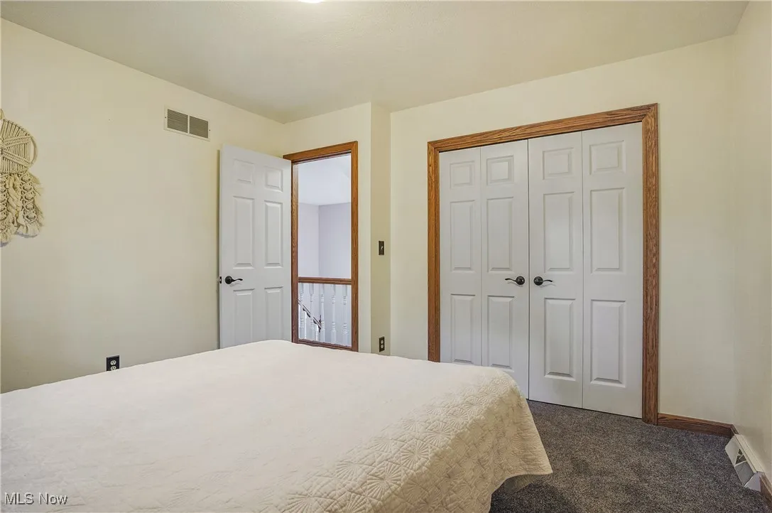 Bedroom featuring dark colored carpet and a closet