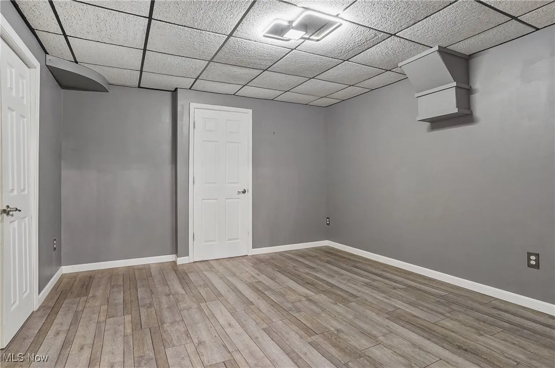 Finished basement featuring a drop ceiling and wood finished floors