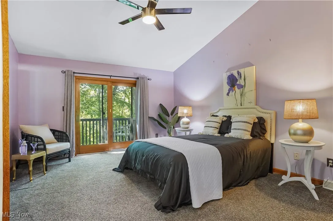 Bedroom featuring carpet, access to outside, lofted ceiling, and a ceiling fan